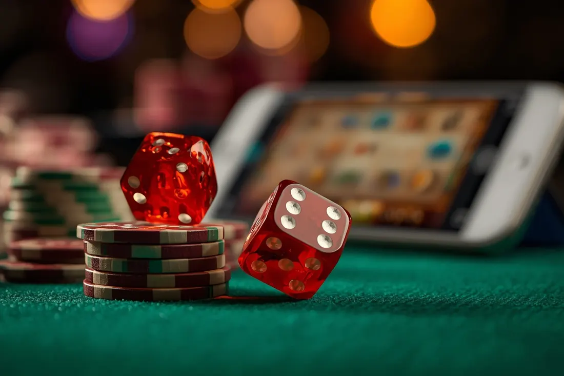 Red dice tumbling over chips in front of a slot game